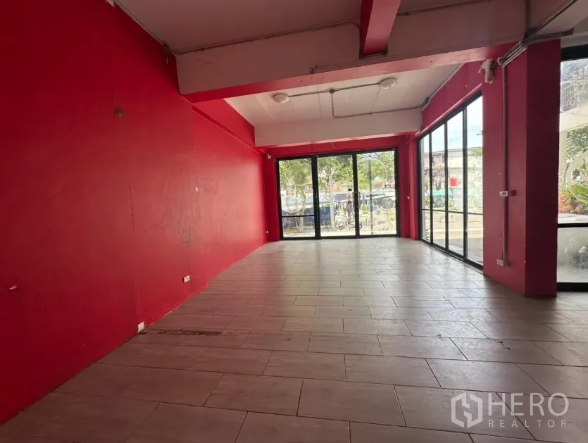Retail Space for rent in Khlong Toei, Bangkok - Long rectangular shop area with red feature walls and wide glass frontage.