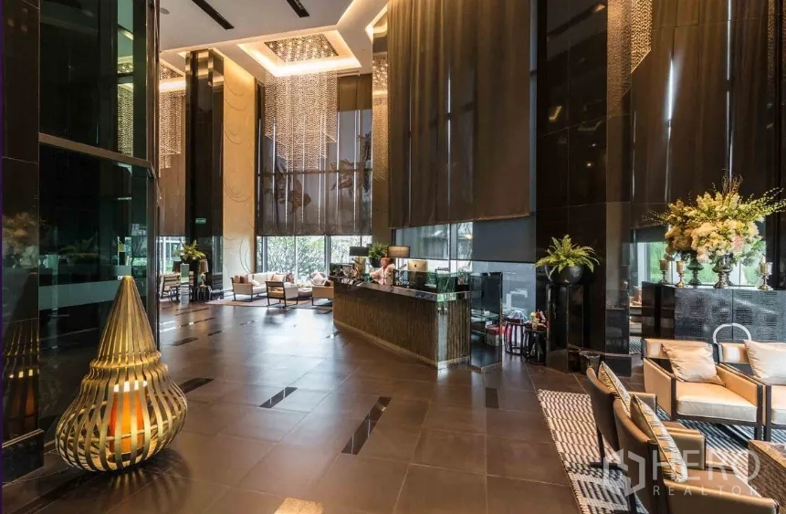 公寓 出租在Sathon, Bangkok - 豪华挑高公寓大堂，水晶吊灯、接待台与休息区，位于沙吞。