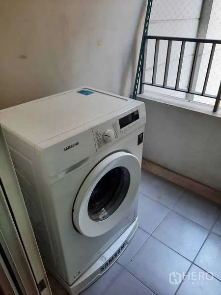 Condominium for rent in Khlong Toei, Bangkok - Washing machine on the service balcony with safety netting.