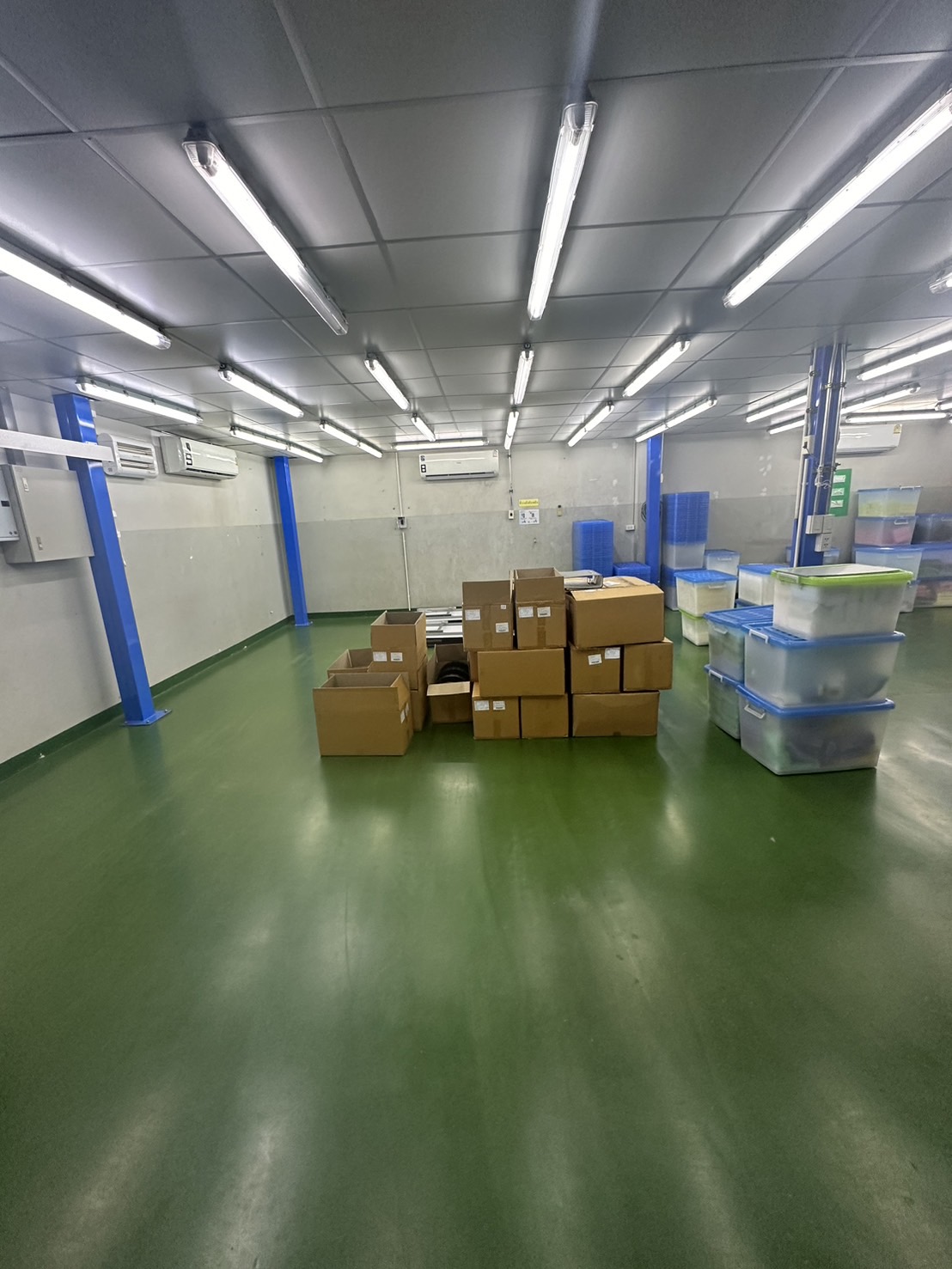 货栈 出租或出售在Lam Luk Ka, Pathum Thani - 宽敞仓储区，纸箱与塑料周转箱在明亮灯光下整齐摆放。