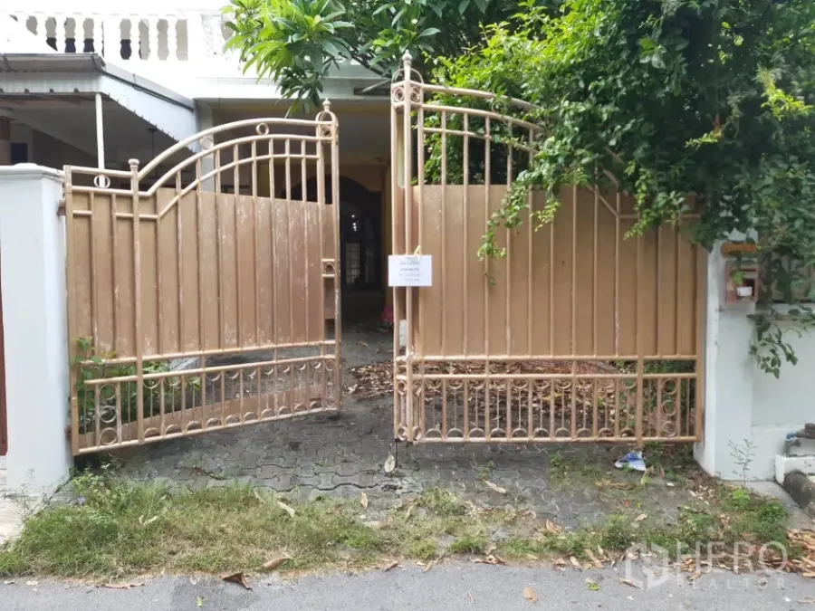 联排别墅 出租在Khlong Toei, Bangkok - 金色金属大门与绿植掩映的联排别墅入口，前方为车道。
