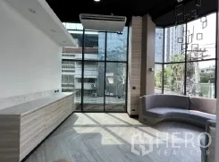 Retail Space for rent in Khlong Toei, Bangkok - Bright corner space with floor-to-ceiling windows, curved built-in seating and urban views.