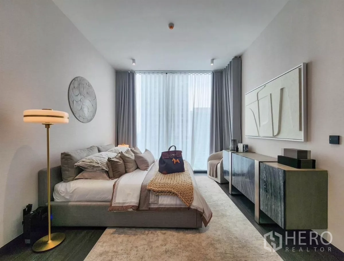 公寓 出租在Bang Rak, Bangkok - 主卧另一视角，长边柜与落地灯，面对大窗。