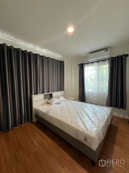 Detached House for rent in Bang Kapi, Bangkok - Second bedroom with double bed, dark curtains and wood floors.
