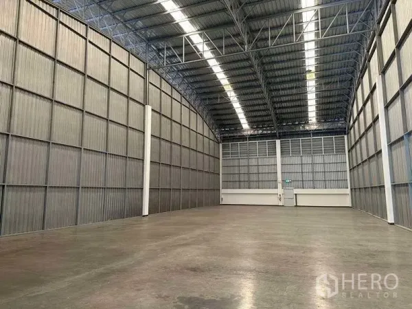 工厂 出租在Bang Sao Thong, Samut Prakan - 仓库内部高挑空间，金属墙体与采光带，抛光混凝土地面。