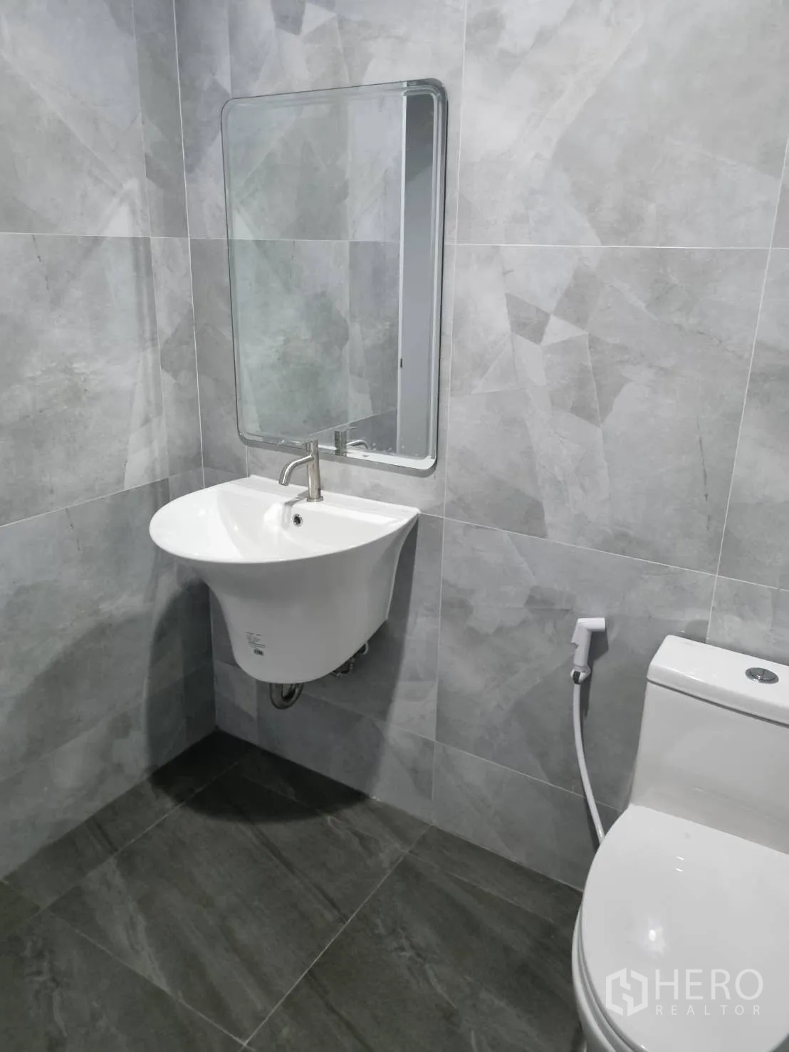 仓库 for rent in Thepharak, Nakhon Ratchasima - 卫生间内设壁挂洗手盆、镜子与坐便器。
