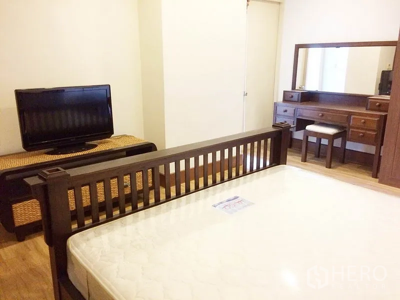 公寓 出租在Khlong Toei, Bangkok - 卧室视角展示床、电视柜和梳妆台。