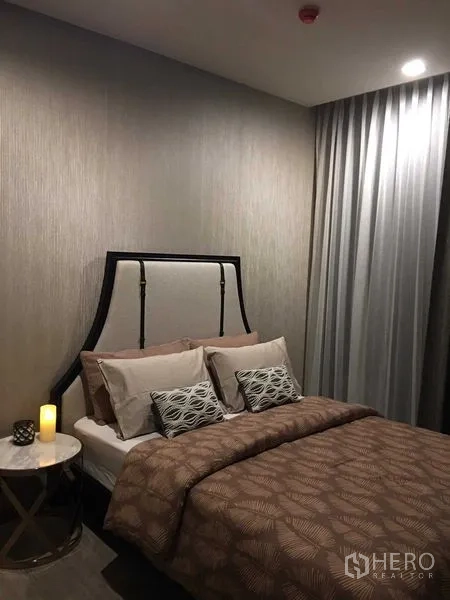 公寓 出租在Watthana, Bangkok - 第二卧室配软包床头、暖色灯光与全遮光窗帘。