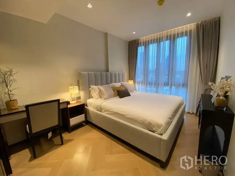 คอนโด ให้เช่าในWatthana, Bangkok - ห้องนอนสว่าง เตียงบุผ้า โต๊ะทำงาน และหน้าต่างสูงจรดเพดาน