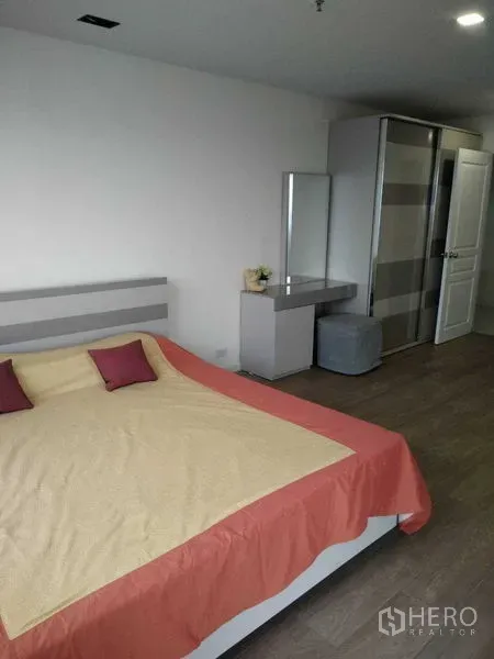 Condominium for rent in Khlong Toei, Bangkok - Second bedroom with king bed, wardrobe, dressing table and neutral decor.