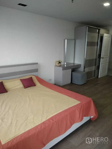 Condominium for rent in Khlong Toei, Bangkok - Second bedroom with king bed, wardrobe, dressing table and neutral decor.