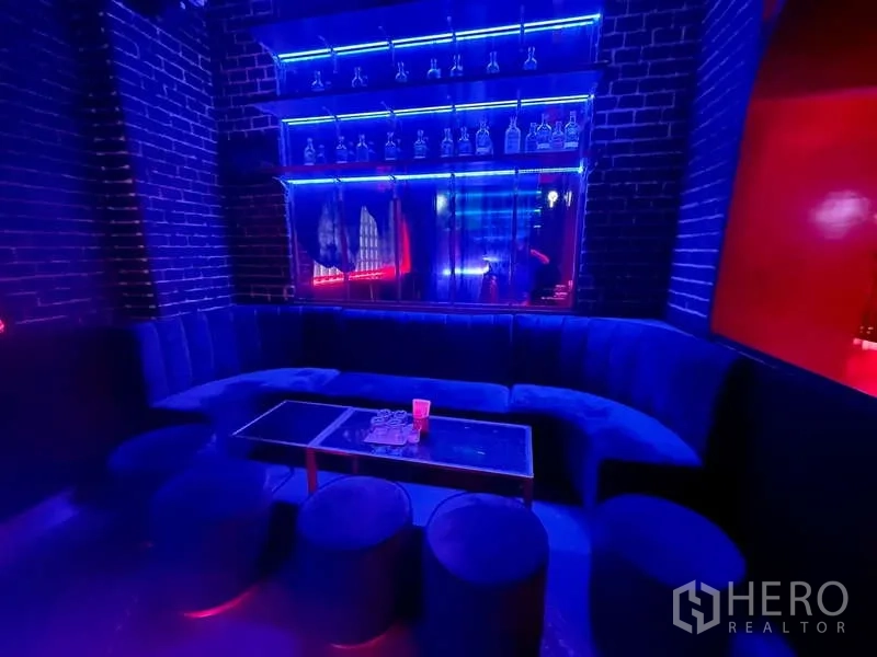 Retail Space for rent in Bangkok - Blue velvet lounge seating with low table and illuminated display shelves.