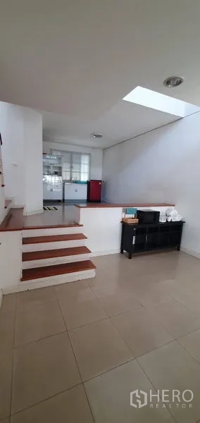 Townhouse for sale in Bang Kapi, Bangkok - Split-level ground floor with tiled flooring, steps up to a bright kitchen and skylight.