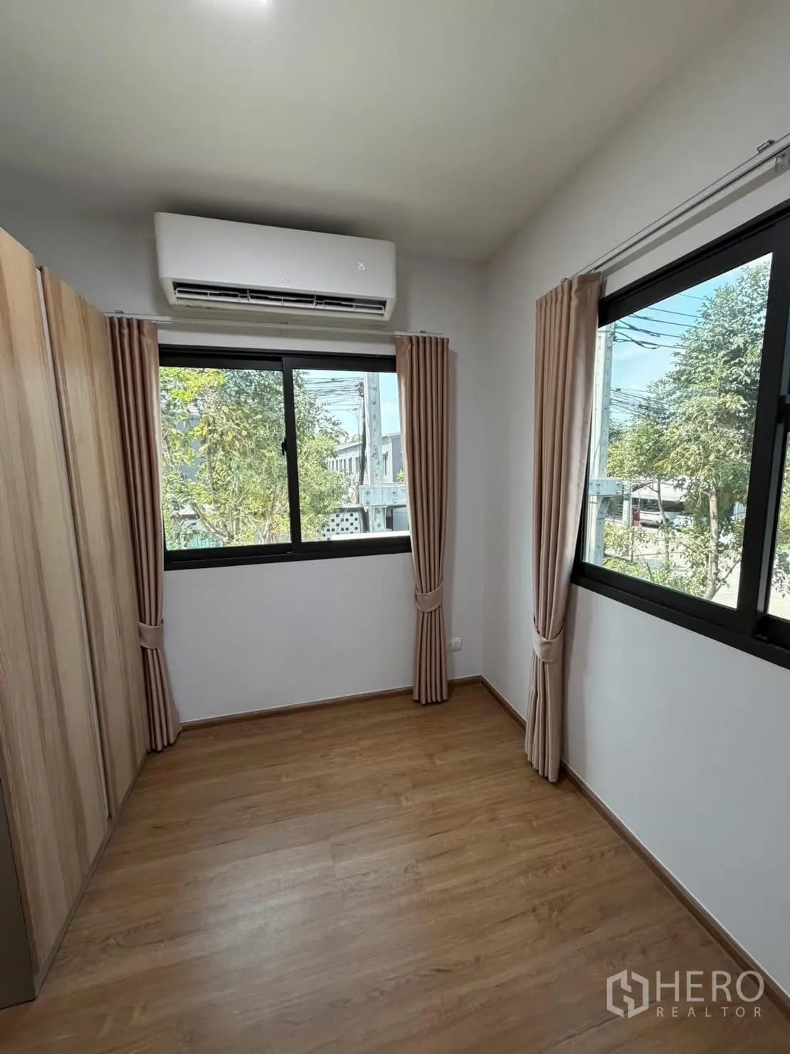 联排别墅 for rent in Bang Phli, Samut Prakan - 次卧采光好，转角两扇窗，空调与木地板，米色窗帘。