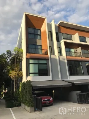 Townhouse for sale in Suan Luang, Bangkok - Modern three-storey townhouse facade with balconies and a covered carport