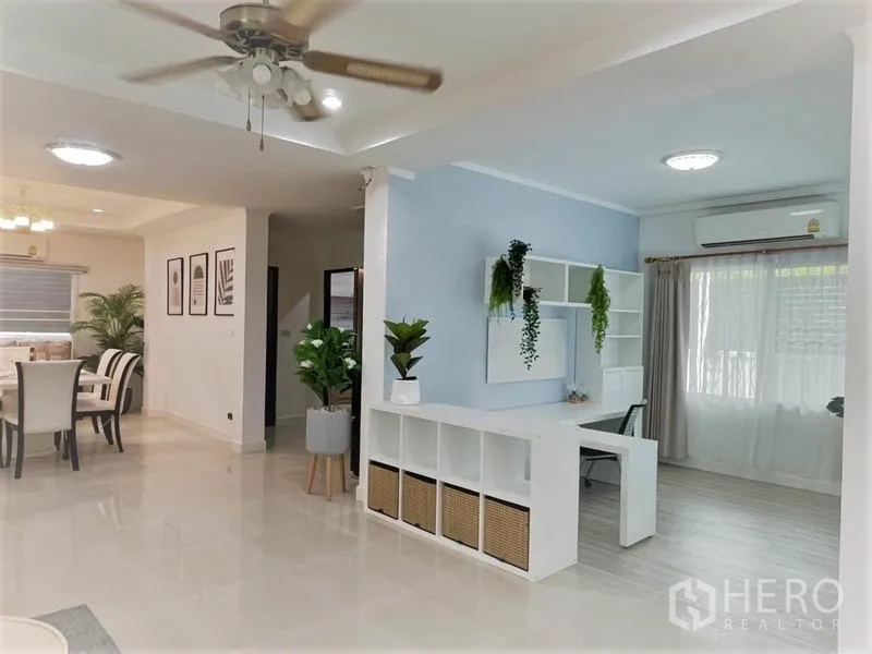 独立式住宅 出租在Suan Luang, Bangkok - 开放式客餐厅与工作区，亮面地砖、吊扇及收纳柜。
