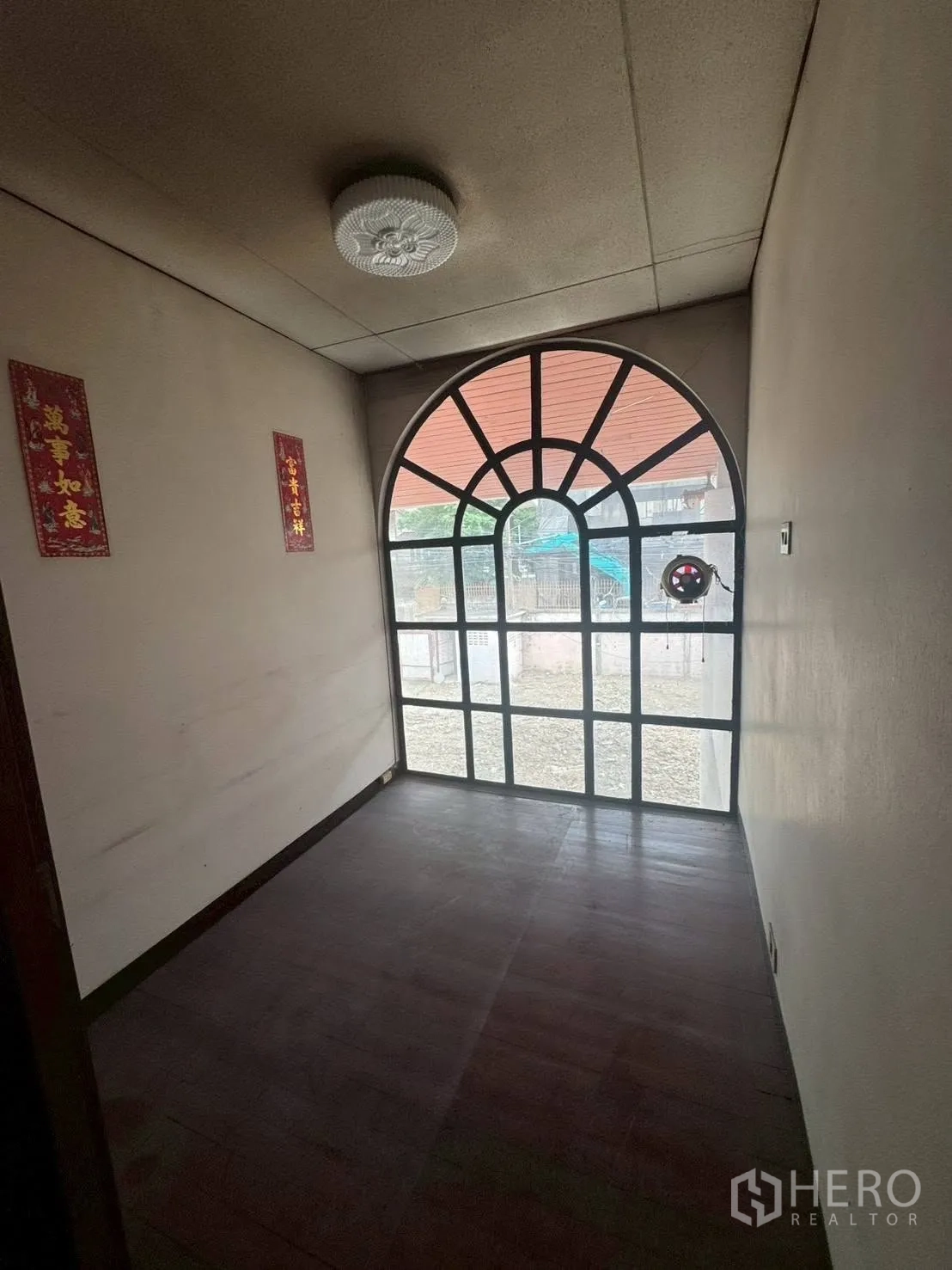 独栋房屋 for rent or sale in Watthana, Bangkok - 狭长空间，尽端为大型拱形窗面向庭院。