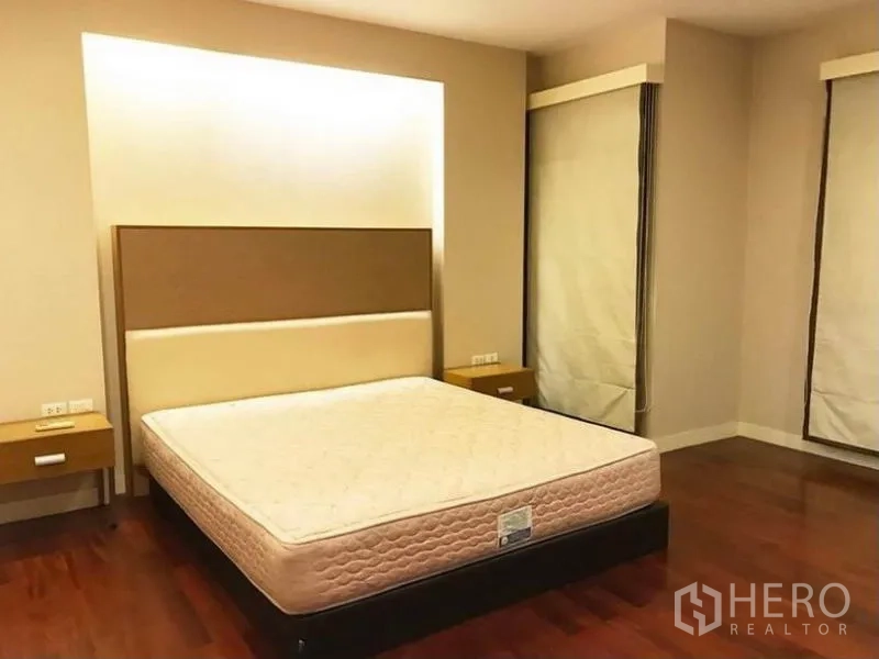 Townhouse for rent in Wang Thonglang, Bangkok - Corner bedroom with wood floors, soft lighting and large windows with blinds.