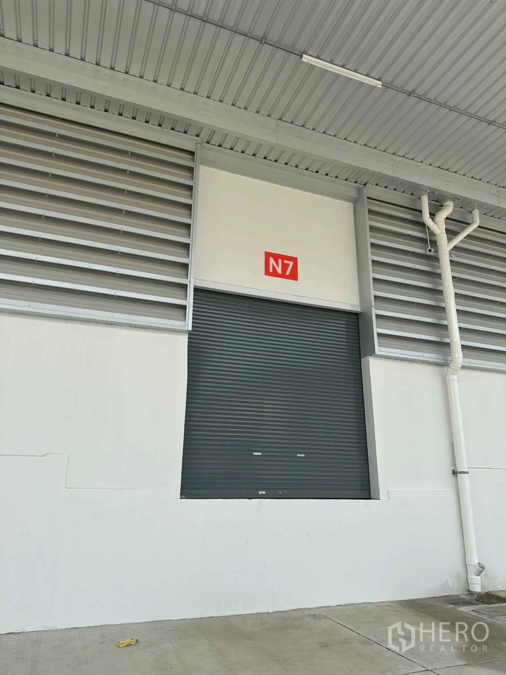 工厂 出租在Khlong Luang, Pathum Thani - 单个装卸口N7特写，保温卷帘门置于金属雨棚下。