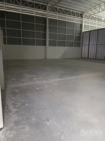 Warehouse for rent in Khlong Toei, Bangkok - Clean concrete slab inside the warehouse under a high steel roof with ventilation panels.