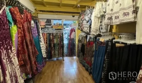 Retail Space for rent in Watthana, Bangkok - Narrow retail interior with colorful clothing racks, tiled floor and glass entrance.