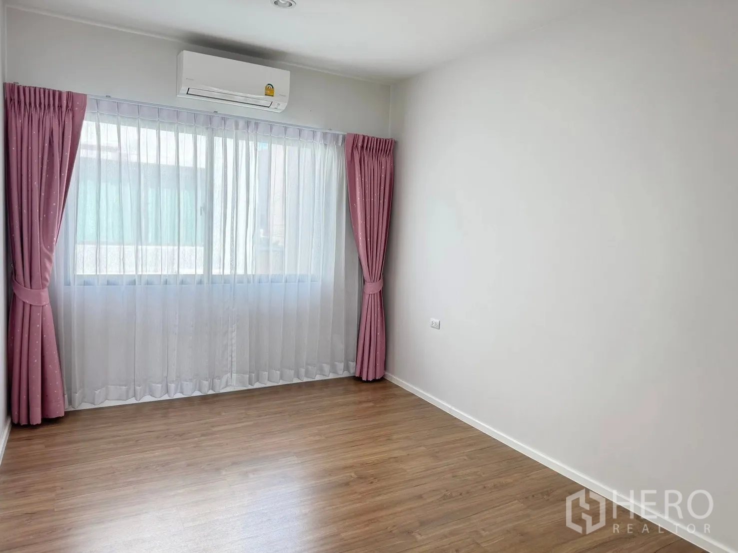 Townhouse for rent in Saphan Sung, Bangkok - Empty secondary bedroom featuring wood floors, pink curtains and air-conditioning.