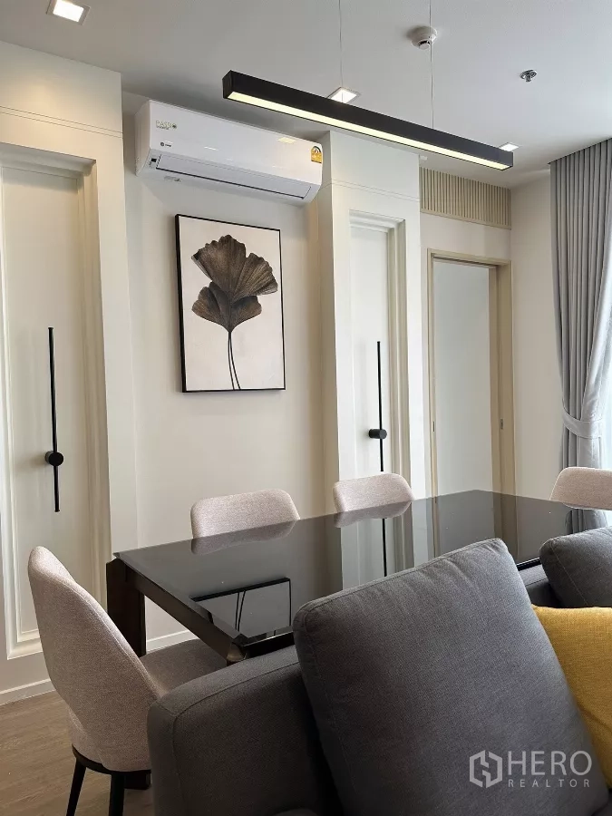 คอนโด ให้เช่าในWatthana, Bangkok - โซนทานอาหาร โต๊ะกระจกสีดำ เก้าอี้บุผ้า และโคมไฟแขวนทรงยาวสไตล์โมเดิร์น