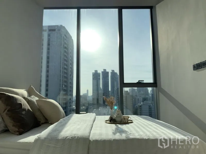 公寓 出租或出售在Khlong Toei, Bangkok - 次卧设大窗与柔和配色，俯瞰城市景致。