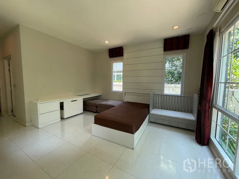 Detached House for rent in Bang Phli, Samut Prakan - Ground-floor bedroom with built-in desk, daybed and garden views.