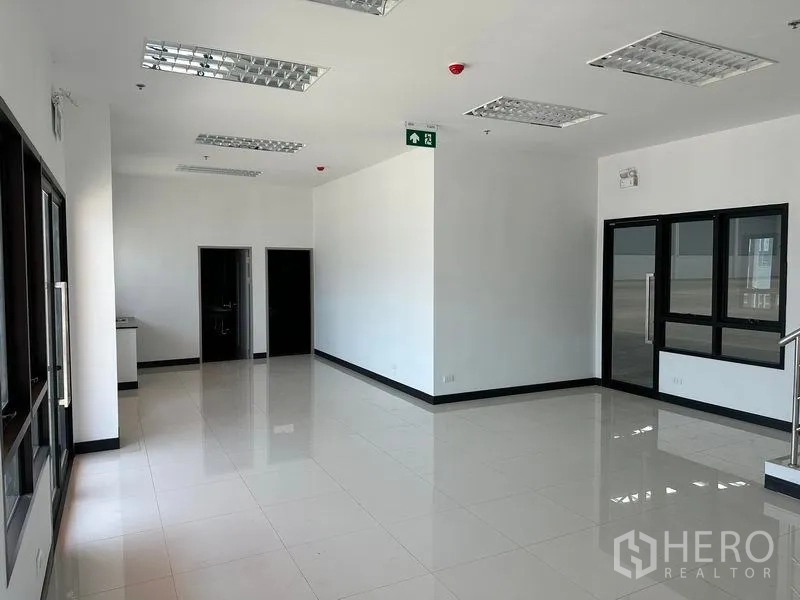 Factory for rent in Bang Phli, Samut Prakan - Spacious office room with large windows and glossy tile flooring.