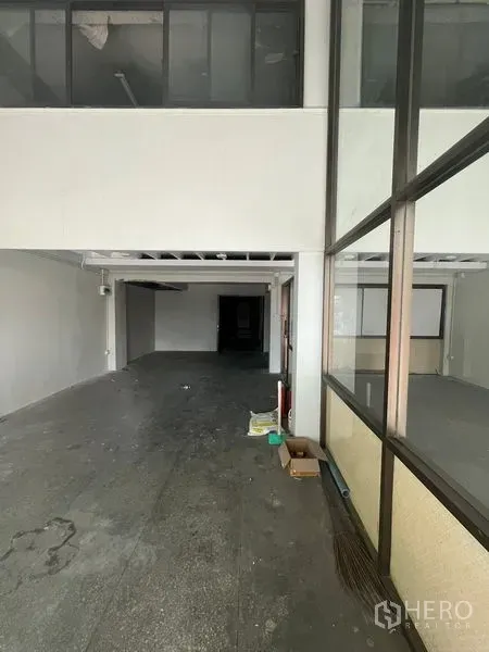 店屋 出租在Khlong Toei, Bangkok - 店铺室内为深进式开放空间，带夹层与玻璃隔间，水泥地面与外露管线。