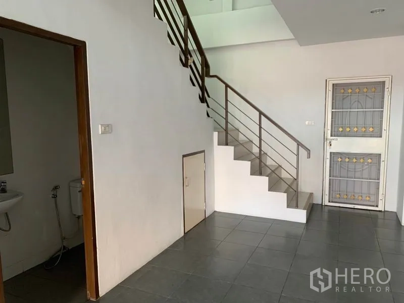店屋 出售在Lat Phrao, Bangkok - 一楼区域设金属栏杆楼梯、楼梯下收纳与卫生间入口。