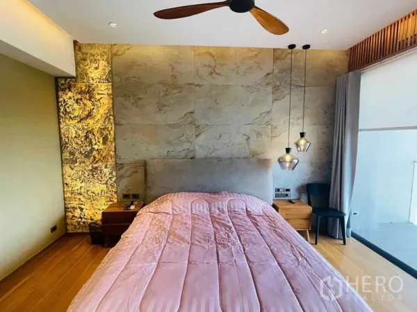 公寓 出租或出售在Watthana, Bangkok - 温馨卧室，石材特色墙、吊灯、吊扇，并可通往阳台。