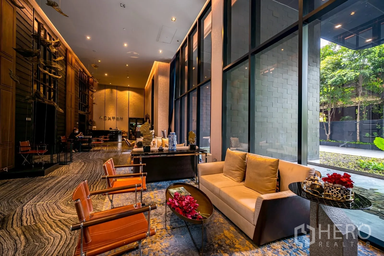 Condominium for rent in Watthana, Bangkok - Grand lobby with high ceiling, comfortable seating and display shelving.