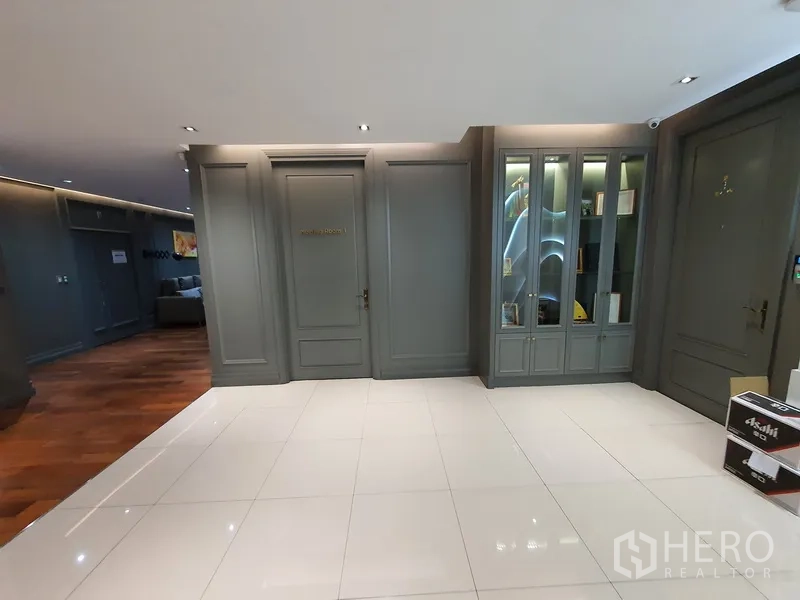 Office Space for rent in Khlong Toei, Bangkok - Lobby corridor with gray paneled doors and glass-front cabinets.