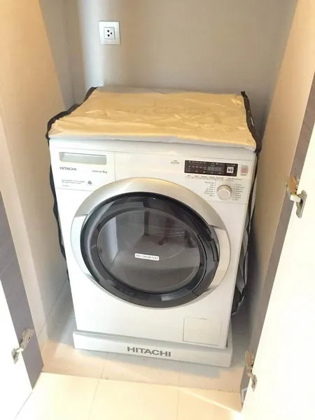 Condominium for rent in Khlong Toei, Bangkok - Front-loading washing machine neatly fitted inside a cabinet.