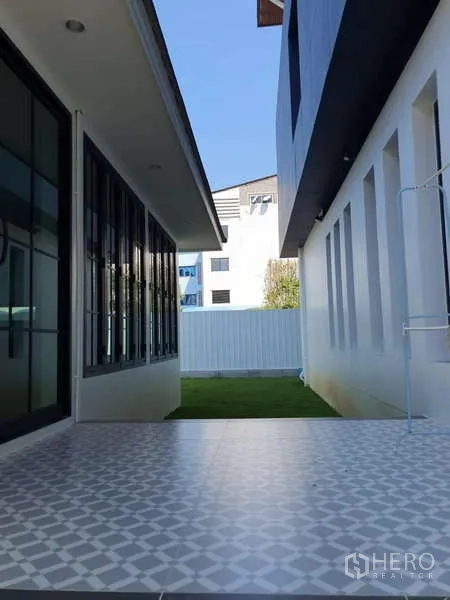 Detached House for rent in Phra Khanong, Bangkok - Covered side patio with patterned tiles between two building wings.