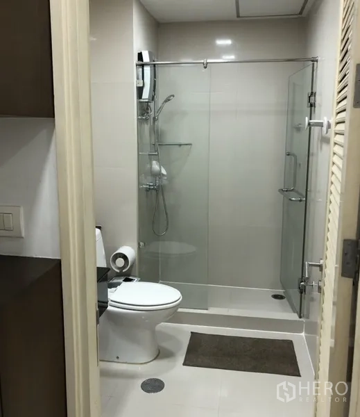 公寓 出租在Khlong Toei, Bangkok - 现代浴室，玻璃淋浴间与坐便器，配色简洁。