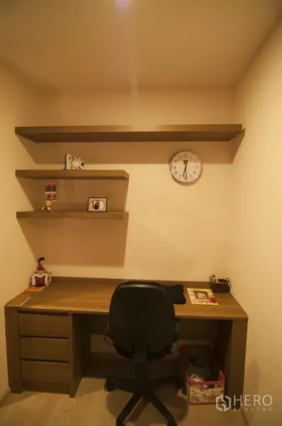 Condominium for rent in Khlong Toei, Bangkok - Compact home office corner featuring a wooden desk, wall-mounted shelves, and task chair.