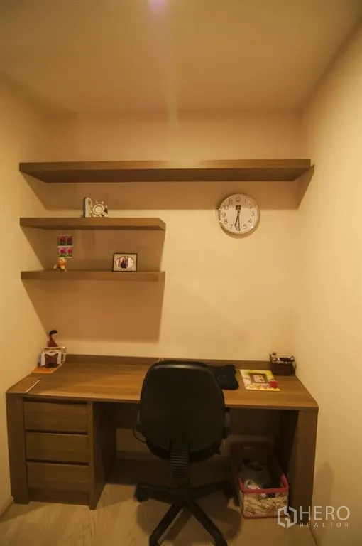 Condominium for rent in Khlong Toei, Bangkok - Compact home office corner featuring a wooden desk, wall-mounted shelves, and task chair.