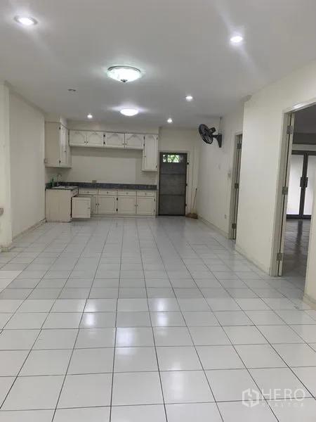 联排别墅 出租在Wang Thonglang, Bangkok - 开放式客餐厅，白色地砖、吊顶灯，配简洁的内置厨房。