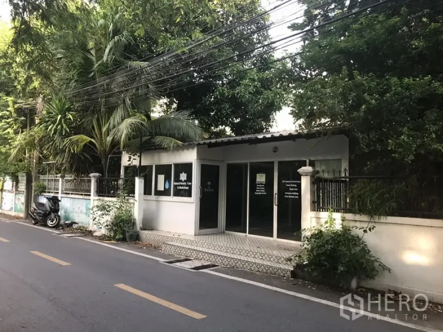 Retail Space for rent in Khlong Toei, Bangkok - Street-level retail unit with glass frontage, tiled entry and lush greenery on a quiet Phra Khanong lane near the BTS.