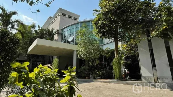 Warehouse for rent or sale in Bangkok Yai, Bangkok - Modern warehouse with curved glass frontage and lush greenery in Bangkok Yai.