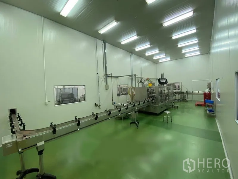 Warehouse for rent in Bueng Kum, Bangkok - Clean room with green epoxy floor and a bottling production line under bright LED lights.