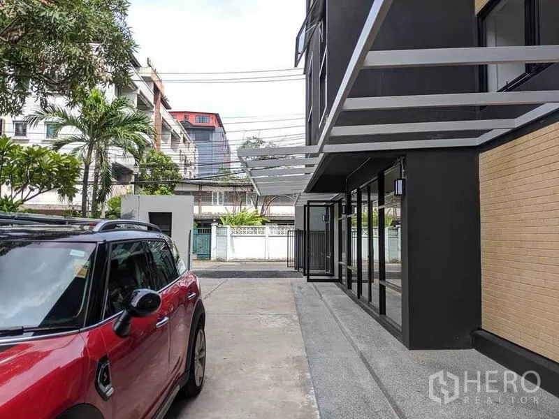 Home Office for rent or sale in Phaya Thai, Bangkok - Driveway and parking area in front of the building with canopy and gate.