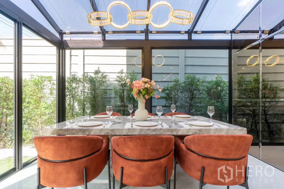Detached House for rent or sale in Prawet, Bangkok - Close-up chandelier above marble dining table inside glass pavilion