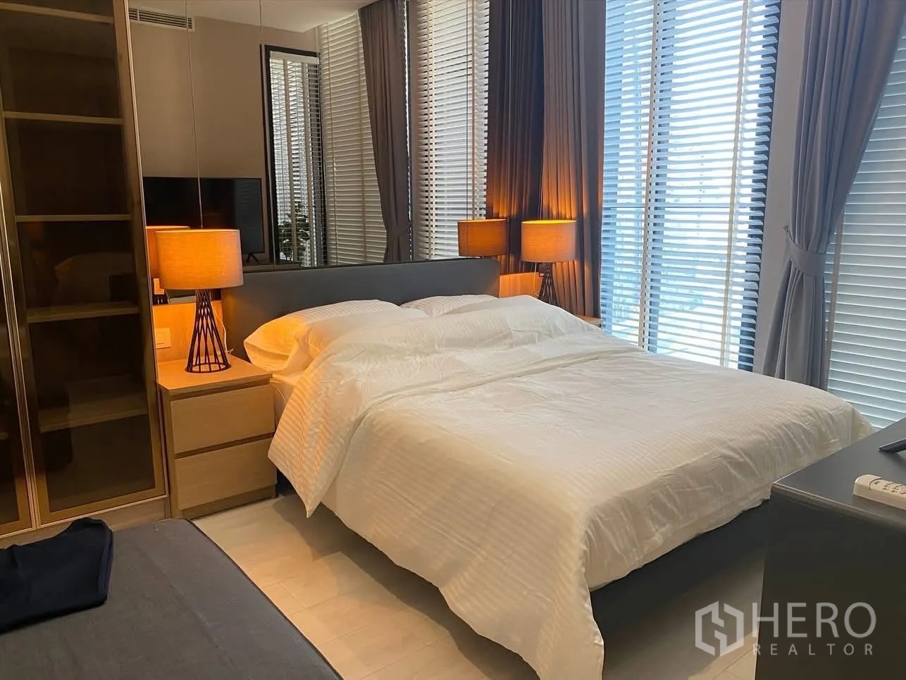公寓 for rent in Pathum Wan, Bangkok - 明亮卧室，落地窗与百叶帘，双床头灯营造氛围。