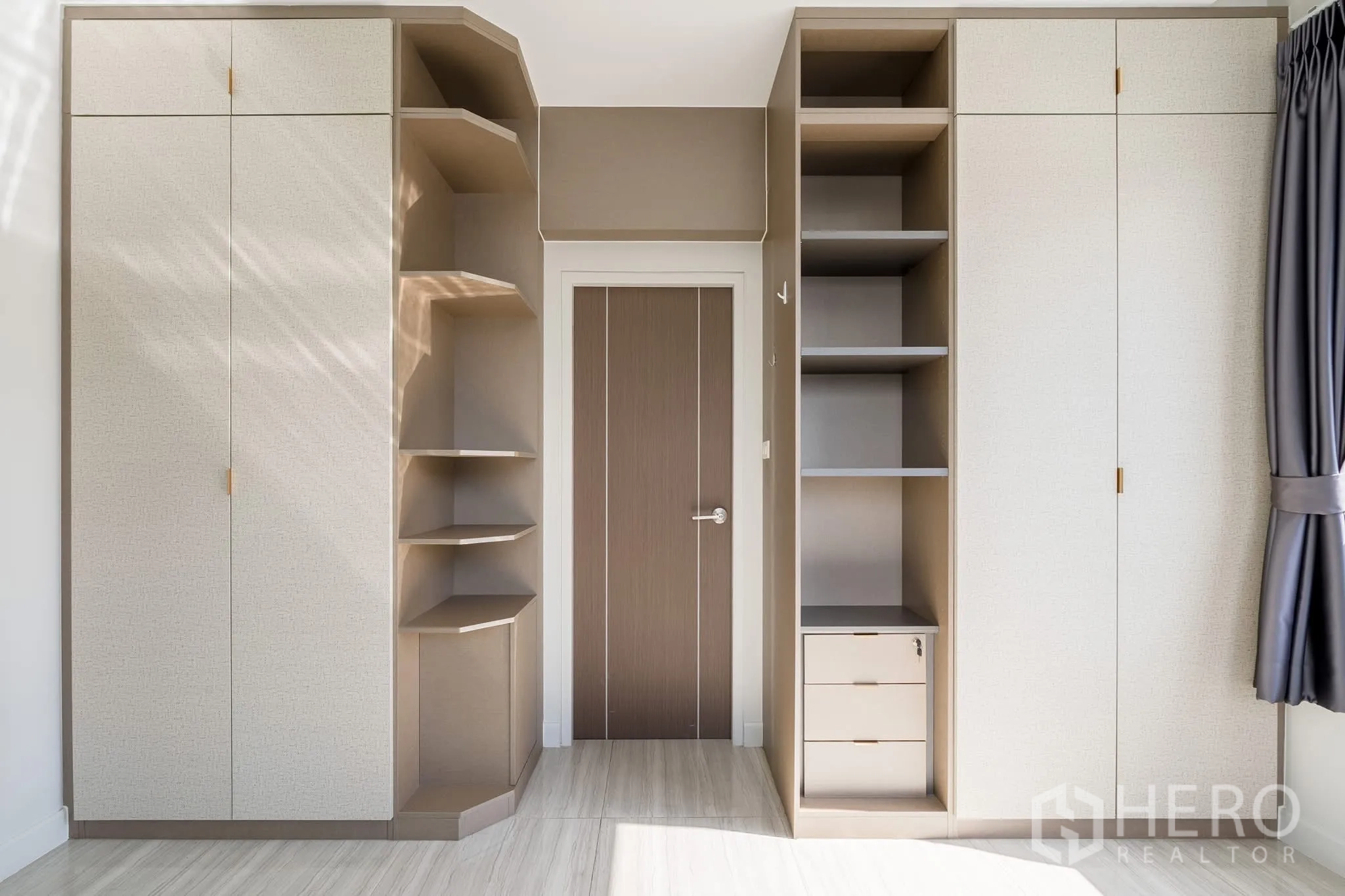 Home Office for rent in Khlong Toei, Bangkok - Built-in wardrobes and open shelving in neutral tones for storage.