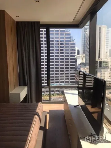 คอนโด ให้เช่าในBang Rak, Bangkok - มุมห้องนอนมีชั้นวางทีวี มองเห็นสกายไลน์ผ่านกระจกสูงจากพื้นจรดเพดาน