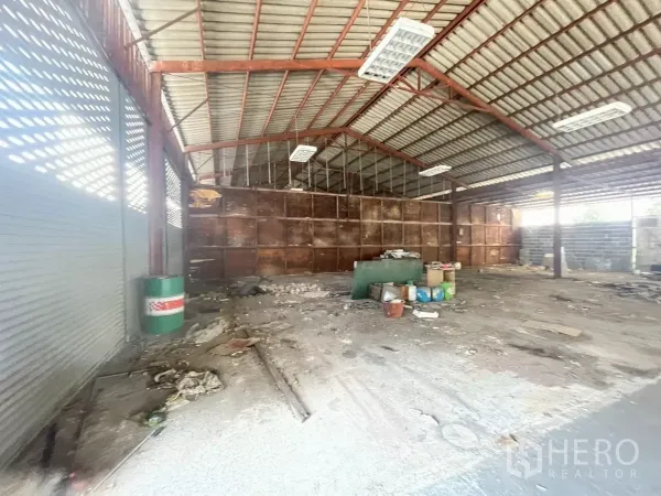 Warehouse for rent or sale in Yan Nawa, Bangkok - Interior showing roller shutters, steel beams and a concrete floor suitable for storage.